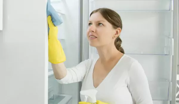 woman cleaning a fridge from inside