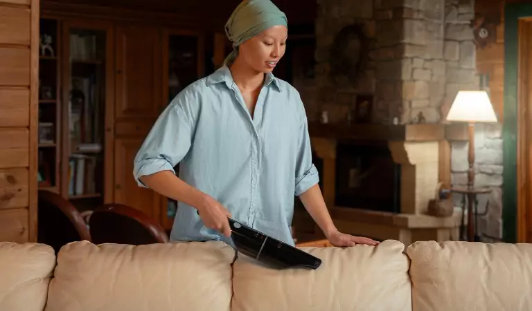 woman cleaning a couch inside of a house