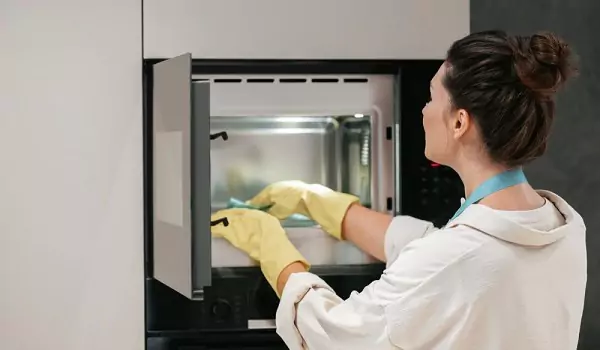 woman cleaning a microwave