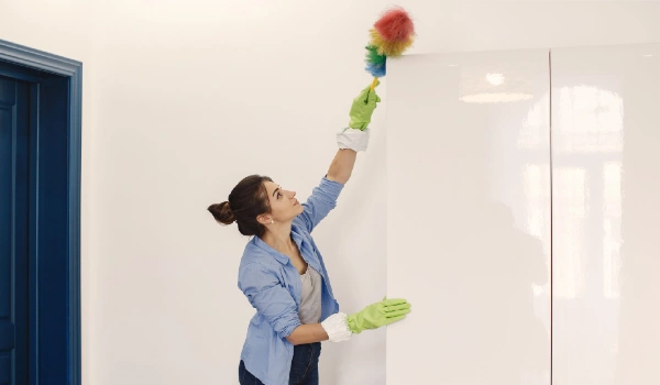 Woman with sponge and rubber gloves cleaning house