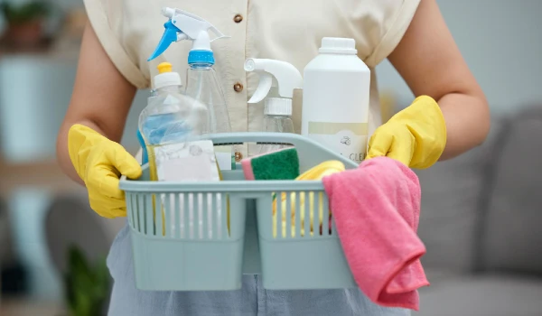 Woman hands and detergent basket for cleaning products housekeeping or disinfection of dirt at home